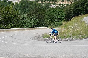 Ein Rennvelofahrer legt sich in die Kurve