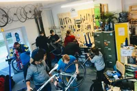 Stundenten und Studentinnen schrauben zusammen an ihren Velos.