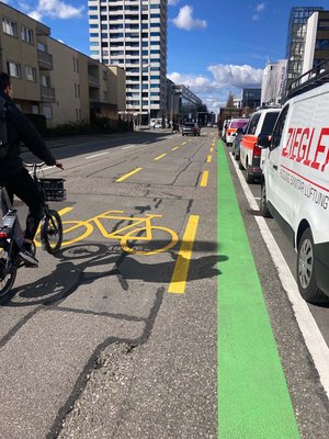 Velovorzugsroute Baslerstrasse. Ein Radfahrer fährt einem Radweg, rechts ist ein grüner Streifen auf den Boden gemalt.