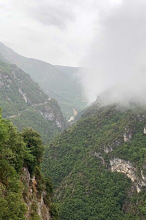 Regenwolken hängen über Berggipfeln