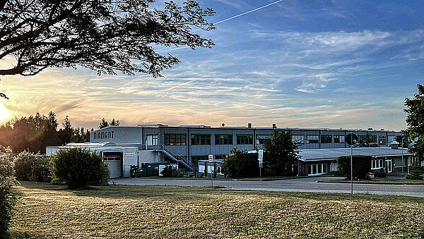 140 Jahre Diamant. Fabrikgebäude mit Himmel in Abendrot.