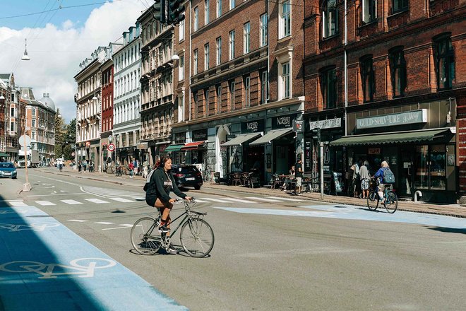 Velofahrerin fährt in Kopenhagen über die Strasse