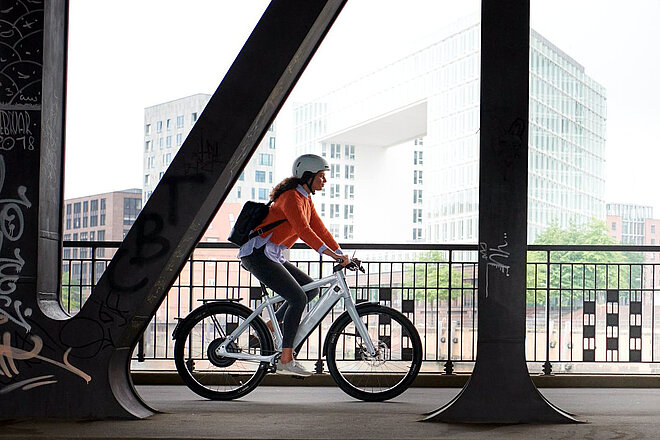Schnelle E-Bikes sind gefragt. Eine Frau fährt auf einem weissen Elektrovelo. 
