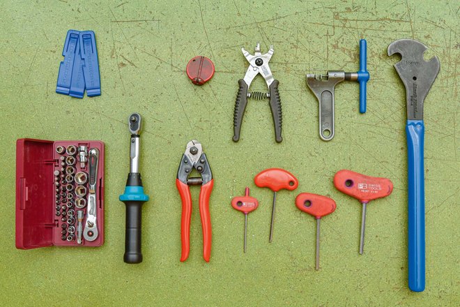 Viele Werkzeuge liegen auf einer Werkbank ausgebreitet da.