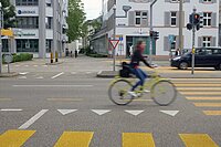 Eine Frau fährt mit dem Velo auf dem Steinengraben in Basel