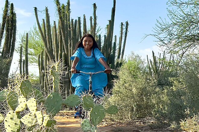 Tern spendet 1 Prozent des Nettogewinns. Eine Frau fährt auf dem Velo zwischen Kakteen. 