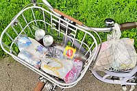 Velo mit Fahrradkorb in dem Abfall liegt
