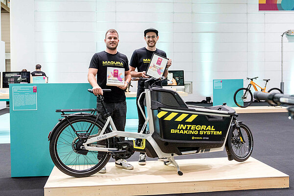 Zwei Männer stehen hinter einem Urban Arrow E-Lastenrad.