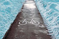 Von Schnee geräumter Radweg.