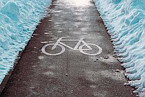 Von Schnee geräumter Radweg.