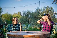 Zwei Frauen sitzen im Garten an einem Tisch