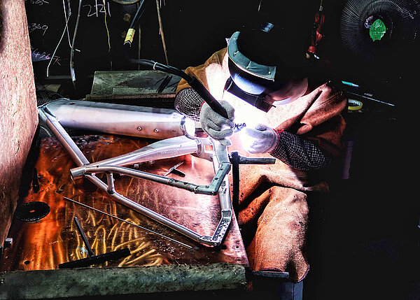 Reynolds hat seinen ersten Nachhaltigkeitsbericht veröffentlicht. Ein Arbeiter schweisst einen Fahrradrahmen. 