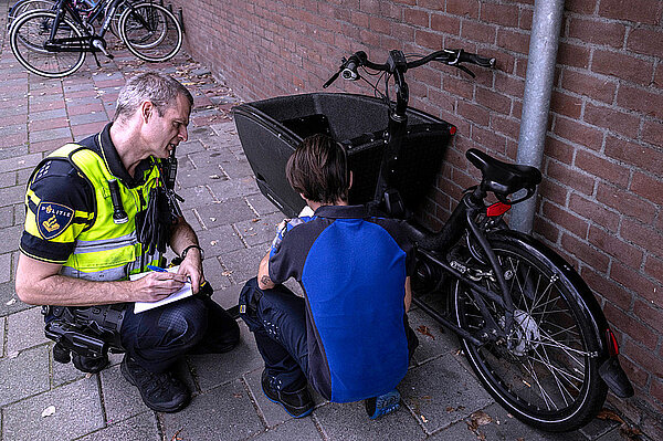 Comodule und Urban Arrow spannen zusammen. Polizisten untersuchen ein Lastenrad.