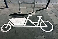 Lastenvelo auf Autoparkplatz in der Schweiz.