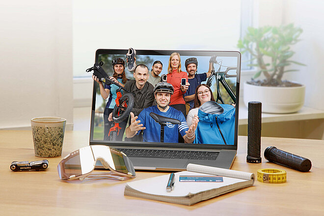 Ein PC-Monitor steht auf einem Tisch, daneben liegt ein Notizblock. 