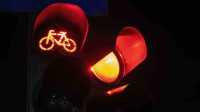rotes Lichtsignal Veloampel und Rotlicht leuchtet aus schwarzem Hintergrund
