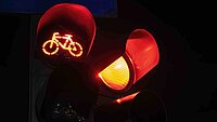 rotes Lichtsignal Veloampel und Rotlicht leuchtet aus schwarzem Hintergrund
