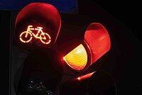 rotes Lichtsignal Veloampel und Rotlicht leuchtet aus schwarzem Hintergrund