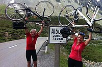 Ein Mann und eine Frau halten ihre Rennvelos in die Luft