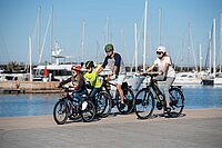 Accell Group wird herabgestuft. Eine Familie fährt auf Velos ein Hafenbecken entlang. 