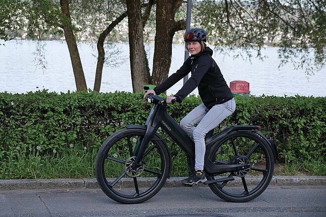 Test Twinner T1 Pro LE. Eine Frau fährt auf einem schwarzen E-Bike.