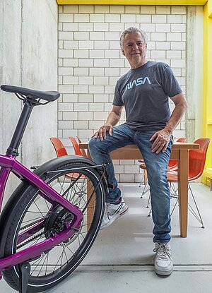 Die S-Pedelecs Opium und Stromer «ST7» waren die Überflieger der Eurobike. Ein Mann mit grauem Haar und T-Shirt sitzt auf einem Tisch.