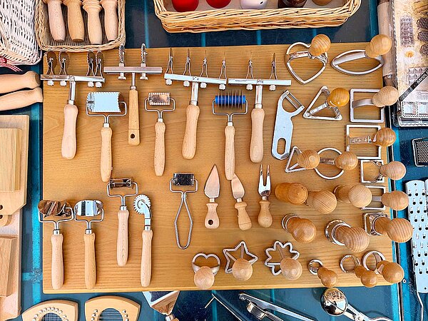 Utensilien zur Pastaherstellung liegen auf einem Tisch.