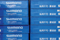 Shimano Quartalszahlen 2024. Blaue Shipping-Container mit der Aufschrift Shimmano.