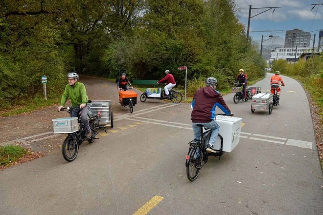 Albert Koechlin Stiftung subventioniert Cargobikes in der Innerschweiz. Personen fahren auf Latenrädern auf einer Strasse. 