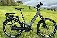 Test Moustache J E-Bike. Ein Elektrovelo steht auf einer grünen Wiese.