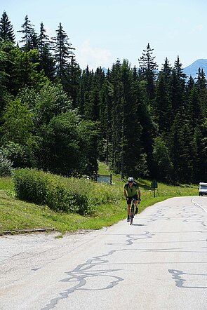 Ein Mann fährt mit dem Fahrrad einen Pass hinauf