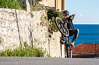 Der codice della strada besagt, dass in Italien alle Velos mit Licht ausgerüstet sein müssen. Ein Biker fährt auf dem Hinterrad in Finale Ligure. 