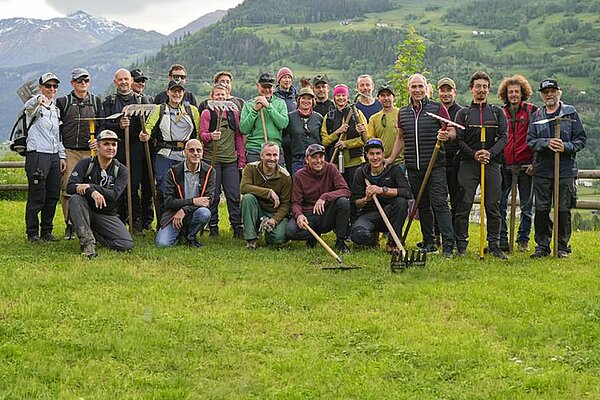 Eine Gruppe von Menschen steht auf einer grünen Wiese.