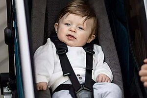 Kleinkind sitzt in einem Fahrradanhänger.