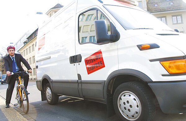 Ein Radfahrer steht neben einem Lieferwagen. 
