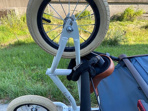 Laufrad mit Veloschloss am Veloanhänger befestigt