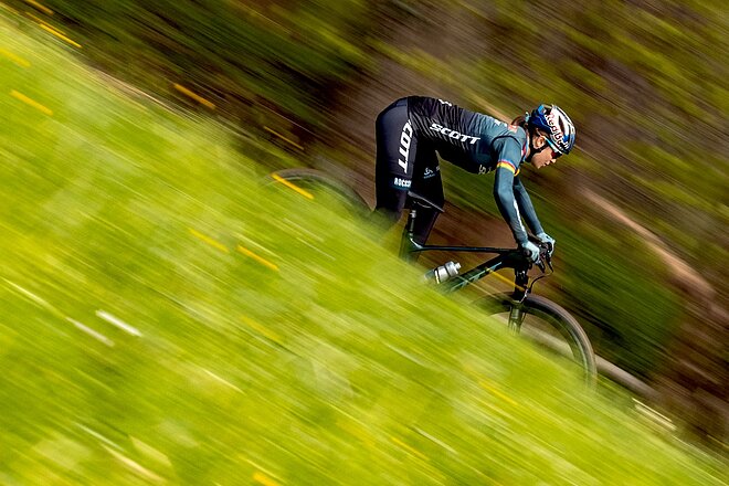 Eine Frau fährt auf einem Mountainbike einen Hang hinunter