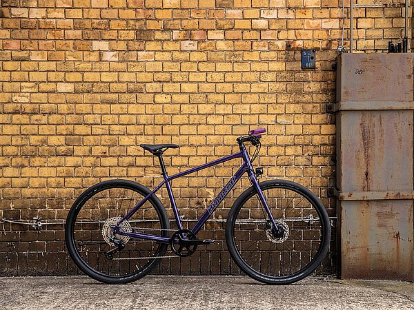 Lila Farrahd steht vor Backsteinwand.