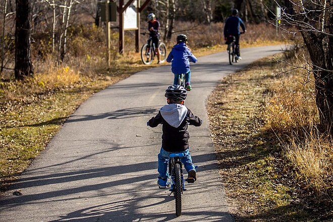 Velofahren auf einem leichten Velo ist für Kinder deutlich einfacher. Kinder fahren auf einem Waldweg Velo