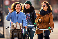 Frauen mit Velos im Strassenverkehr.