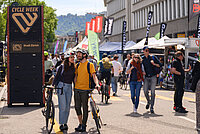 Ein Mann und eine Frau laufen händchenhaltend mit Velos auf einem Weg. 