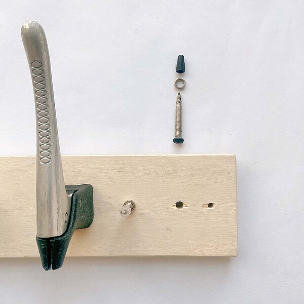 Ein Brett wird an eine Wand geschraubt.