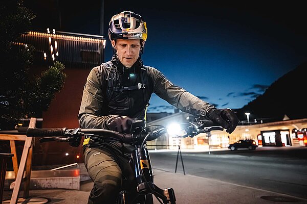 Ein Mann blickt auf den Fahrradcomputer am Lenker seines Bikes. 
