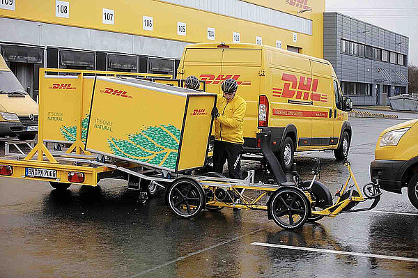 DHL Mitarbeiter auf einem Lastenvelo