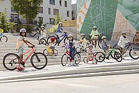 Kinder stehen mit Kinderfahrrädern auf einer grossen Treppe.