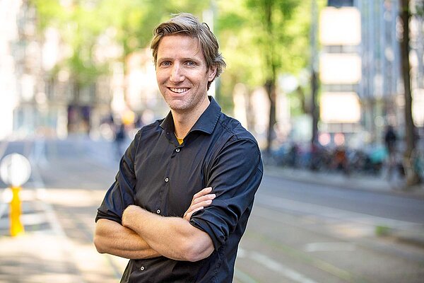 Asoziale Strassen Fietsprofessor. Ein Mann mit blauem Hemd und blonden Haaren.