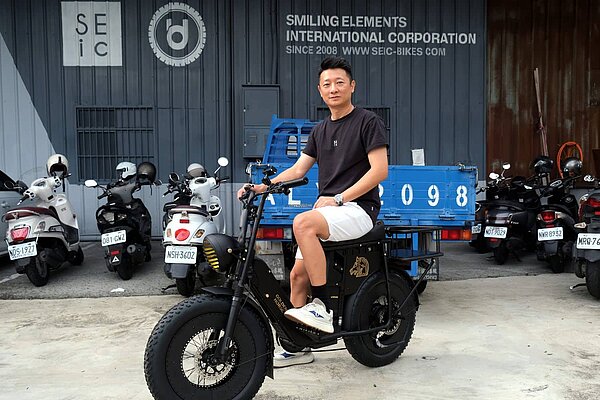 SEIC-Gründer Darren Tan auf dem Unimoke «Golden Horse Edition». Ein Mann mit T-Shirt und Shorts sitzt auf einem Fatbike.