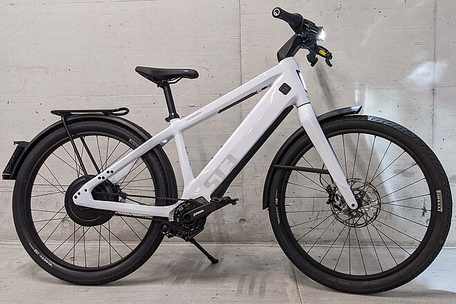 Stromer «ST3» mit Pinion-Getriebe und ABS im Test. Ein weisses E-Bike steht vor einer grauen Mauer.