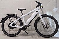 Stromer «ST3» mit Pinion-Getriebe und ABS im Test. Ein weisses E-Bike steht vor einer grauen Mauer.