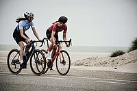 Zyklus Orientiertes Training im Radsport. Rennradfahrerin am Meer. 